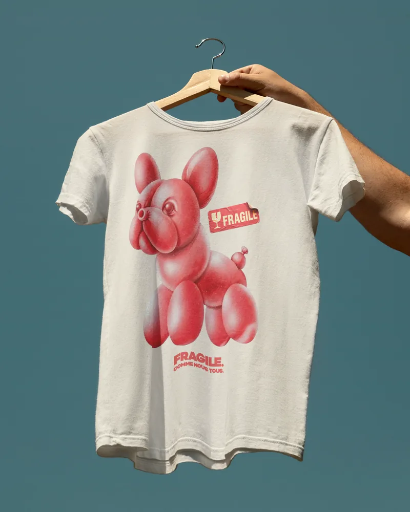 A white tee printed with a red balloon dog and the word FRAGILE.
